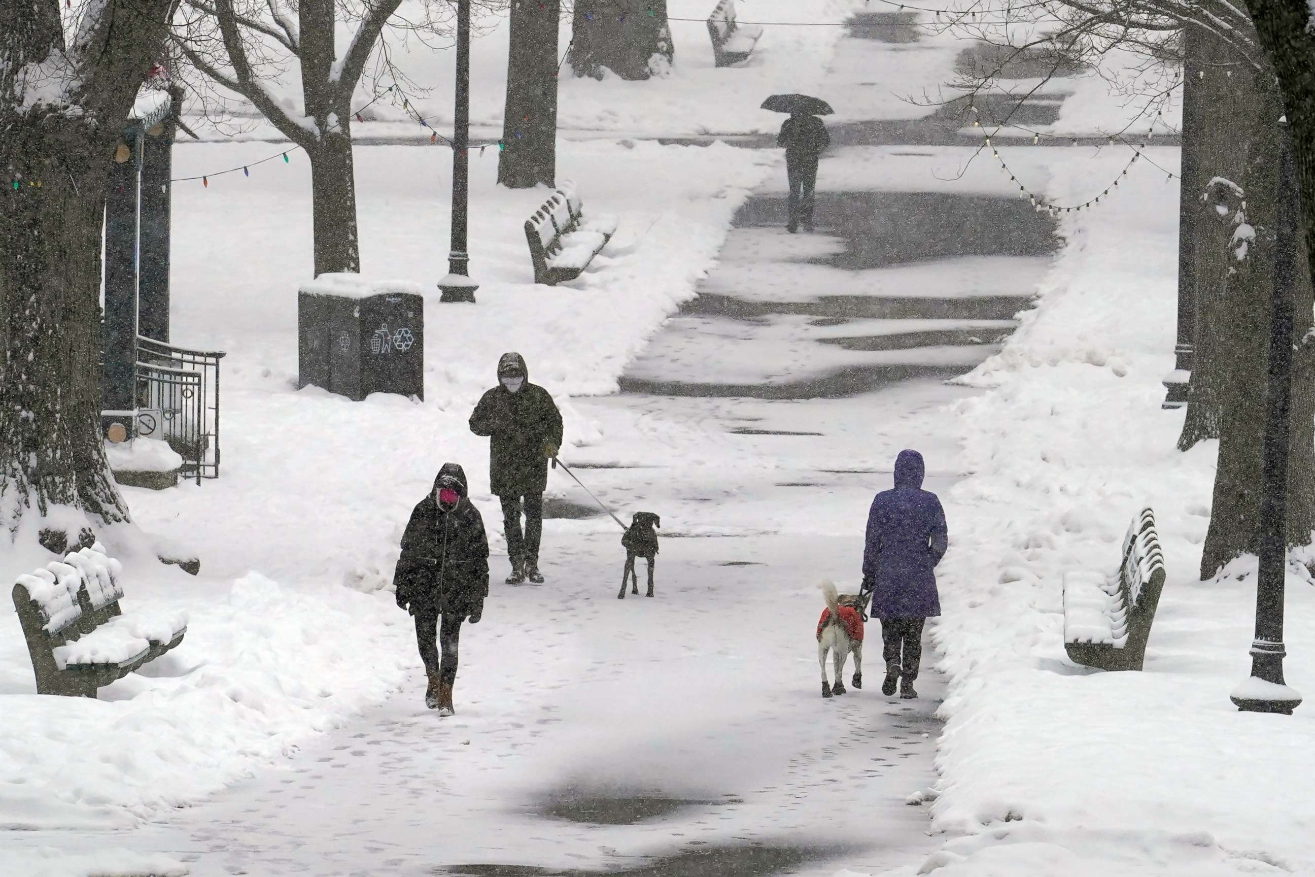 PHOTO: Pedestrians walk along a snow-covered path in the Boston Common, Tuesday, Feb. 9, 2021, in Boston, Mass. 