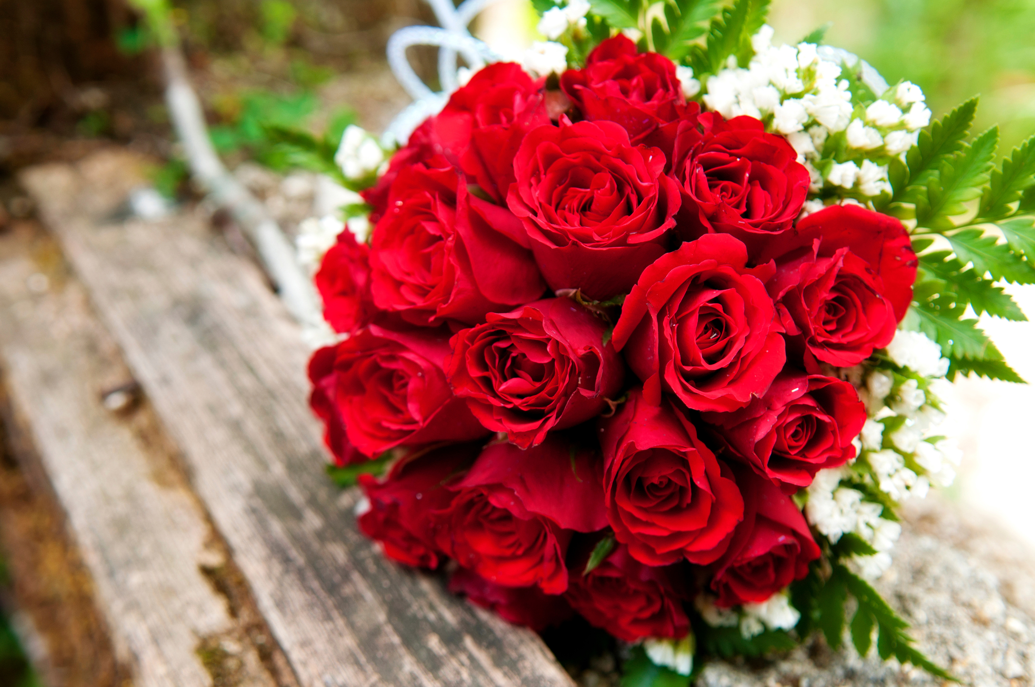 PHOTO: A bouquet of red roses lays on a wooden picnic bench in this stock image. 