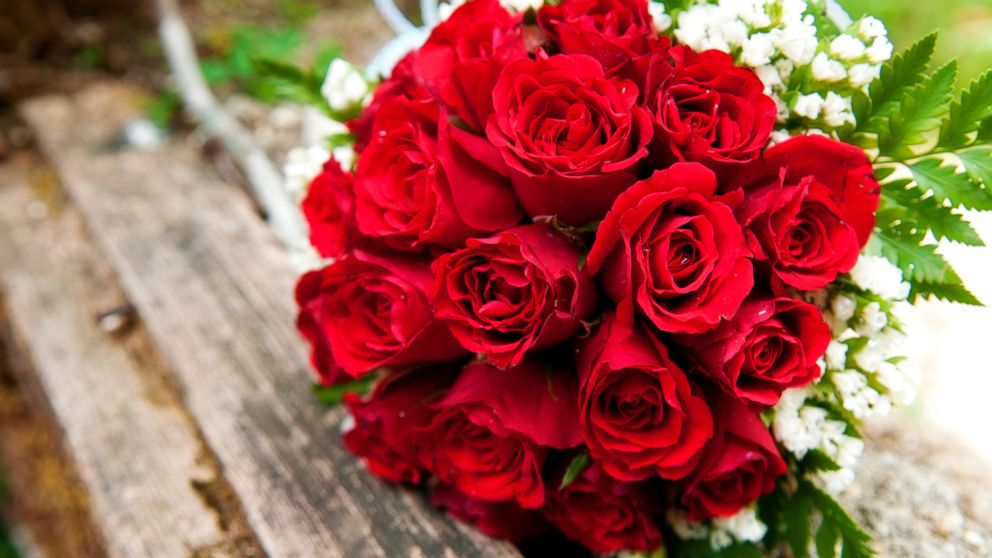 PHOTO: A bouquet of red roses lays on a wooden picnic bench in this stock image. 