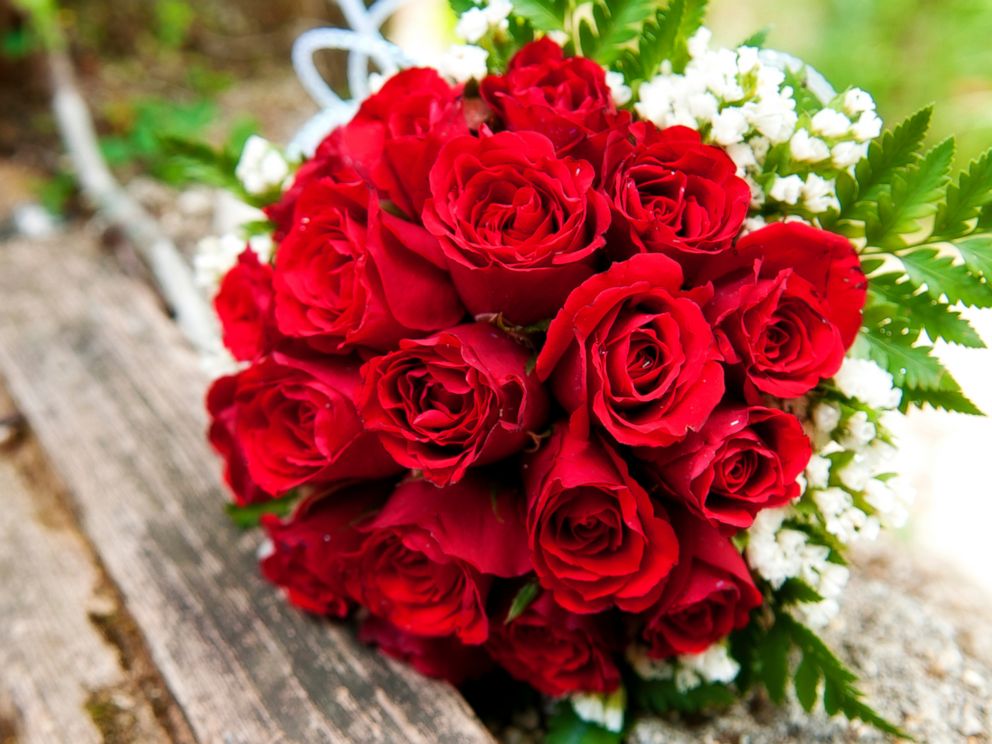 PHOTO: A bouquet of red roses lays on a wooden picnic bench in this stock image. 