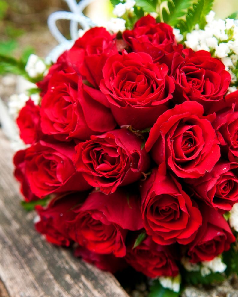PHOTO: A bouquet of red roses lays on a wooden picnic bench in this stock image. 