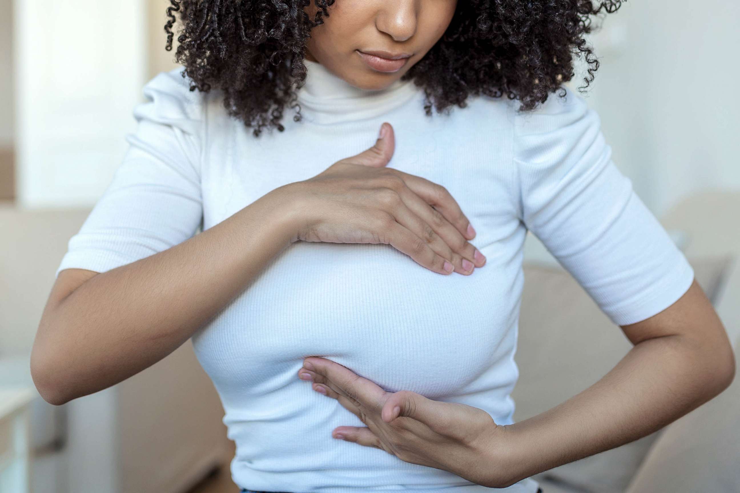 STOCK PHOTO: A woman palpats her breast