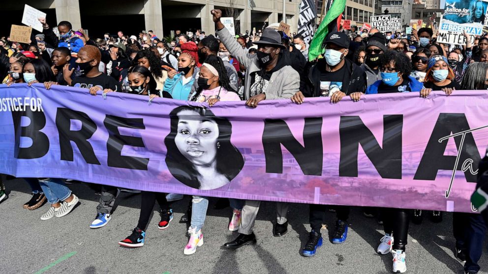 PHOTO: Breonna Taylor's mother Tamika Palmer, center, leads a march through the streets of downtown Louisville on the one year anniversary of Taylor's death on March 13, 2021, in Louisville, Ky. 