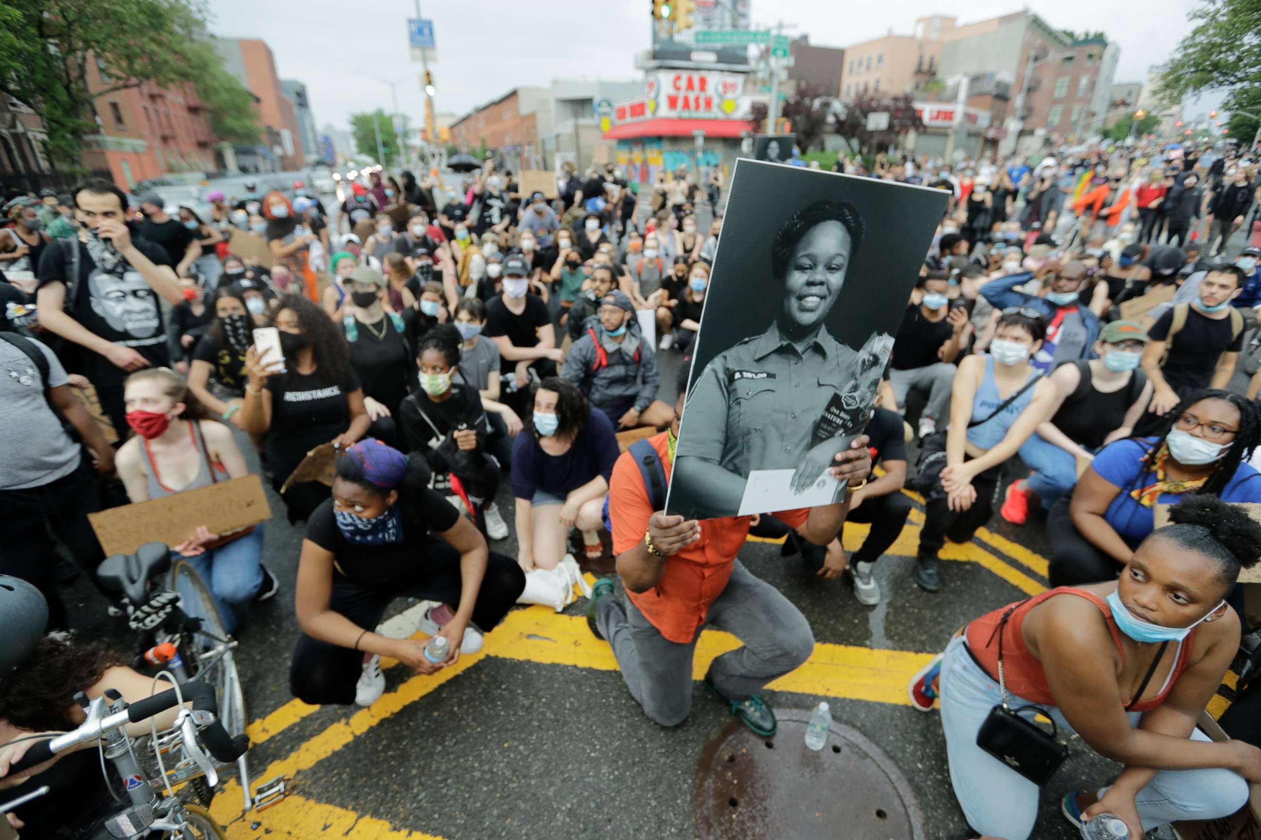 PHOTO: A man holds a photograph of Breonna Taylor on her birthday as he kneels with other protesters on Atlantic Avenue during a solidarity rally for George Floyd on Atlantic Avenue, June 5, 2020, in the Brooklyn borough of New York.