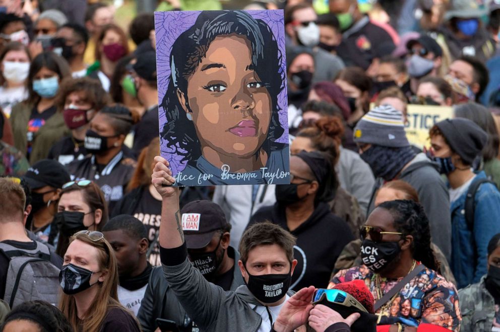 PHOTO: A protestor holds a portrait of Breonna Taylor during a rally in remembrance on the one year anniversary of her death in Louisville, Ky., March 13, 2021. 
