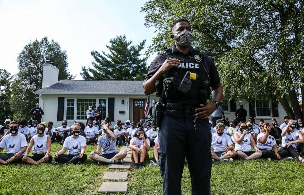 PHOTO: Police stand guard outside the home of Kentucky Attorney General Daniel Cameron as protesters sit in his front yard, chanting Breonna Taylor's name and calling for justice, on July 14, 2020.
