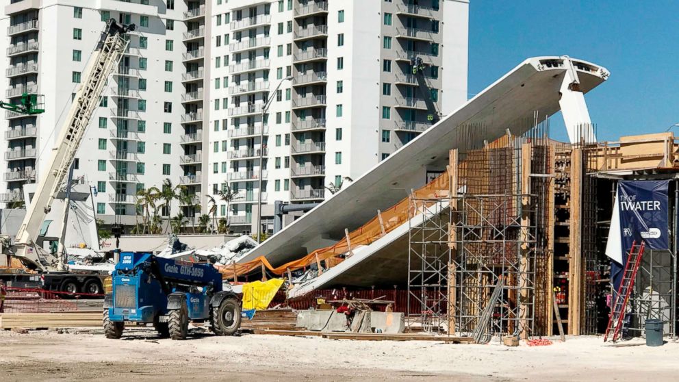 PHOTO: A crane is seen near a newly installed pedestrian bridge, that collapsed, over a six-lane highway in Miami, March 15, 2018.