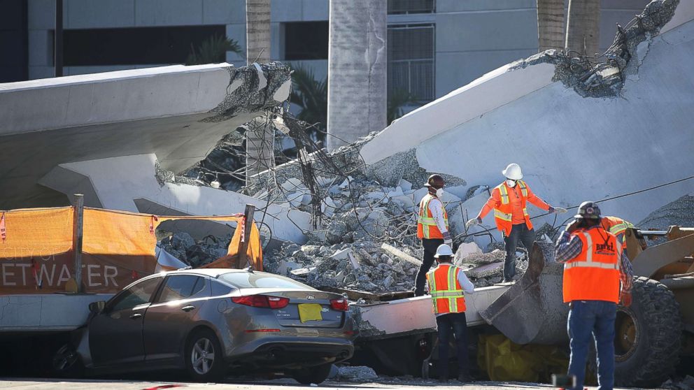 PHOTO: Workers, law enforcement and members of the National Transportation Safety Board investigate the scene, March 16, 2018, where a pedestrian bridge collapsed on March 15 a few days after it was built, in Miami.