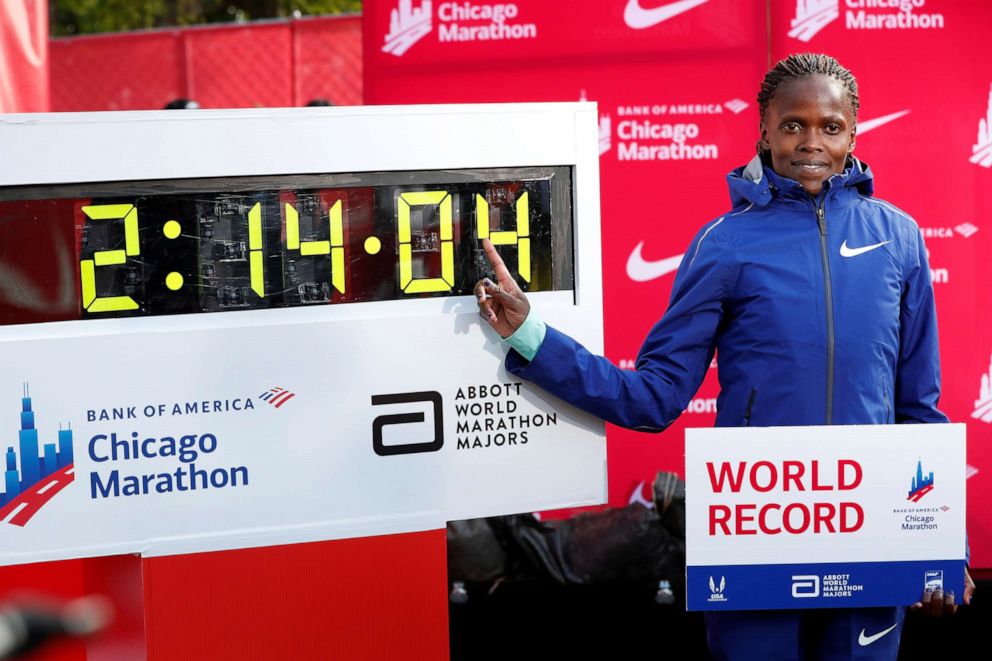 PHOTO: Kenya's Brigid Kosgei celebrates winning the women's marathon next to her new world record at the Chicago Marathon, Oct. 13, 2019.  