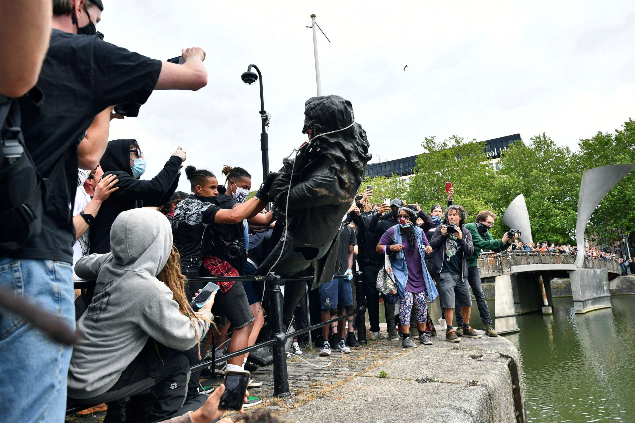 PHOTO: Protesters throw a statue of slave trader Edward Colston into the Bristol harbour, during a Black Lives Matter protest rally, in Bristol, England, June 7, 2020, in response to the recent death of George Floyd.
