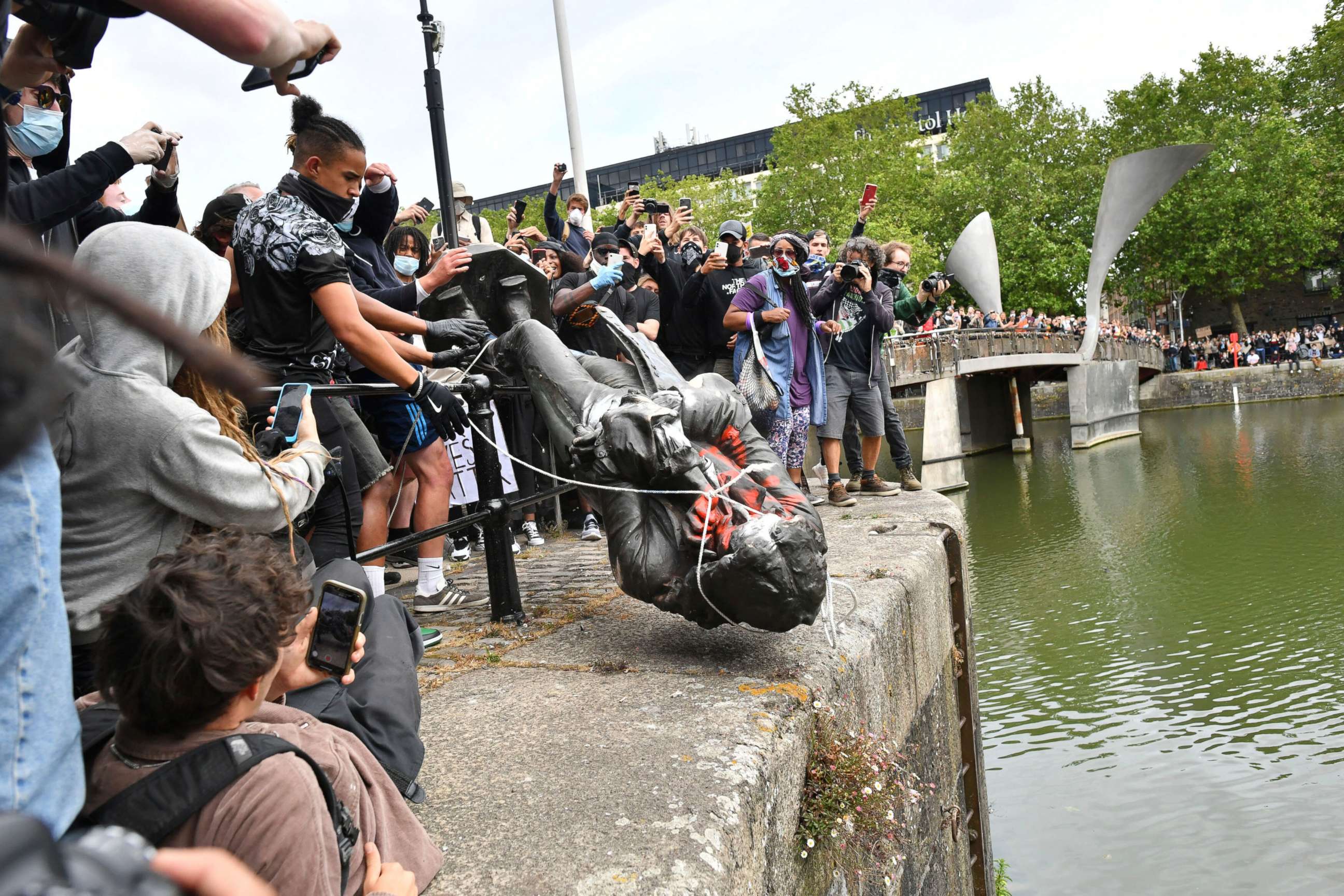 PHOTO: Protesters throw a statue of slave trader Edward Colston into Bristol harbour, during a Black Lives Matter protest rally, in Bristol, England, June 7, 2020, in response to the recent death of George Floyd. 