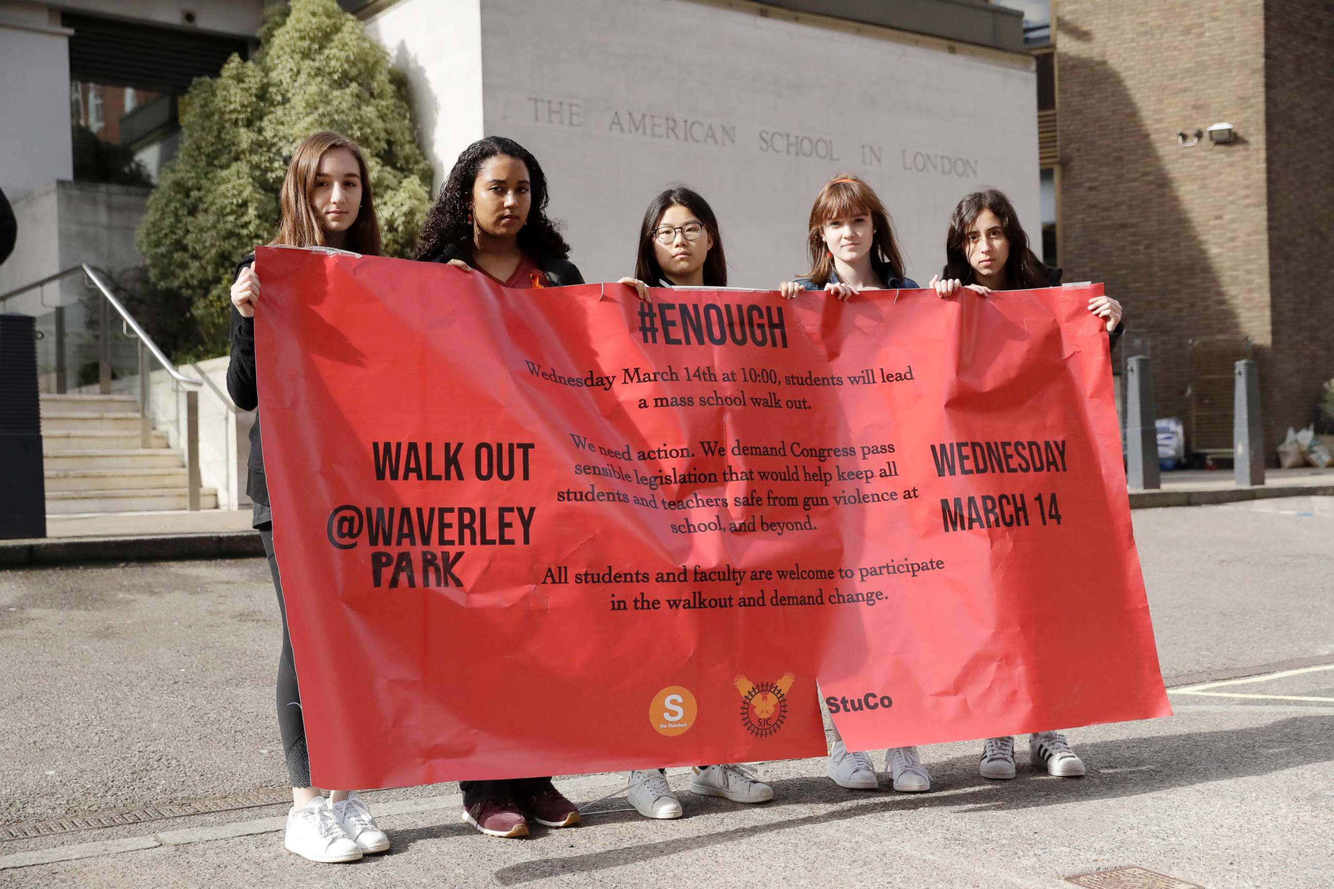 PHOTO: Students pose for photographs with a banner outside the front of the American School in London, after taking part in a 17-minute walkout in the school playground, which was attended by approximately 300 students aged 14-18, March 14, 2018.