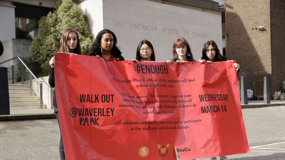 PHOTO: Students pose for photographs with a banner outside the front of the American School in London, after taking part in a 17-minute walkout in the school playground, which was attended by approximately 300 students aged 14-18, March 14, 2018.
