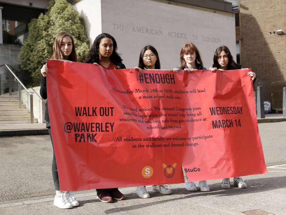 PHOTO: Students pose for photographs with a banner outside the front of the American School in London, after taking part in a 17-minute walkout in the school playground, which was attended by approximately 300 students aged 14-18, March 14, 2018.