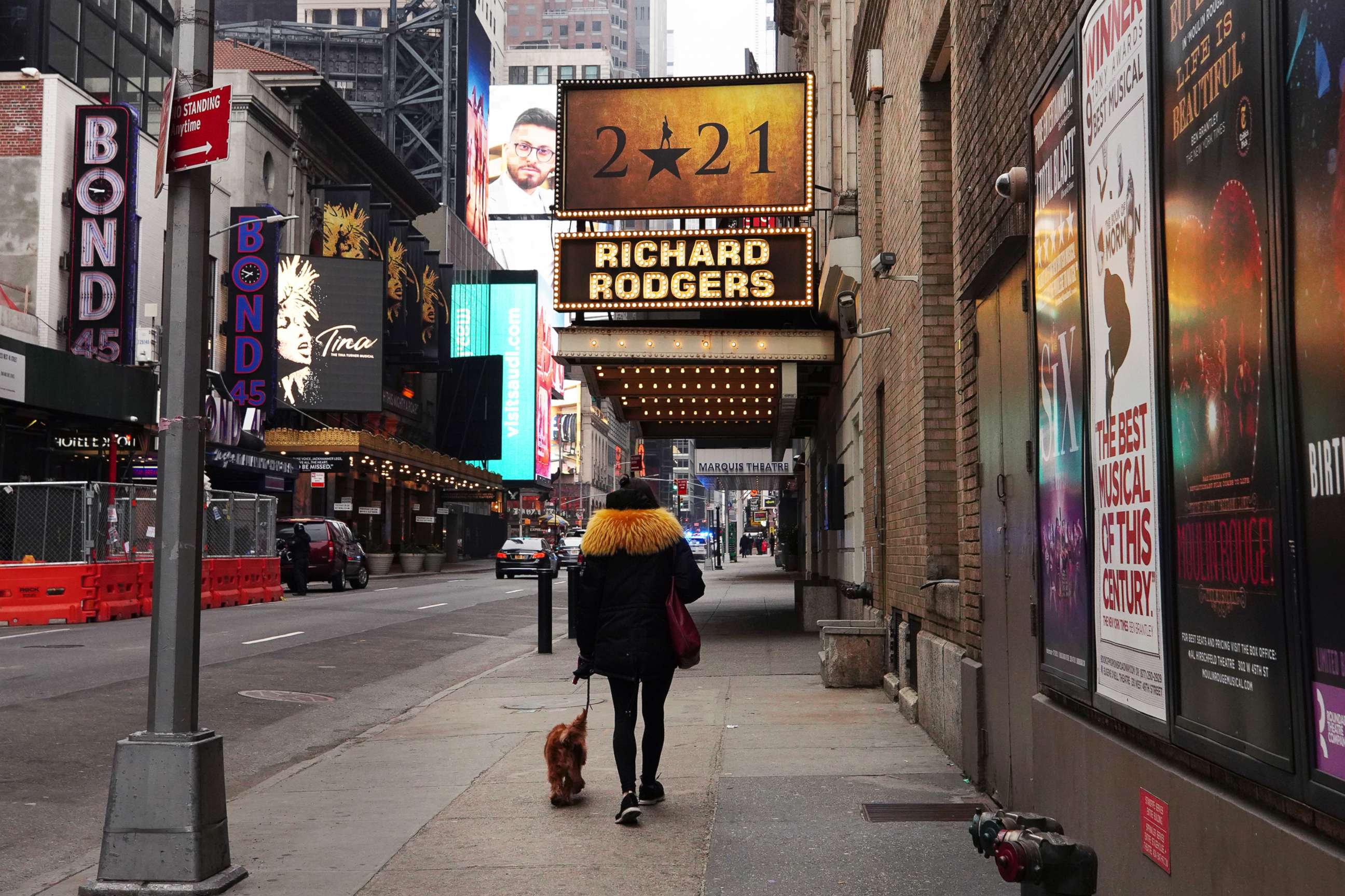 PHOTO: A woman walks her dog down a New York street near Times Square with closed theaters including the Richard Rodgers Theatre, Jan. 15, 2021, in New York City.