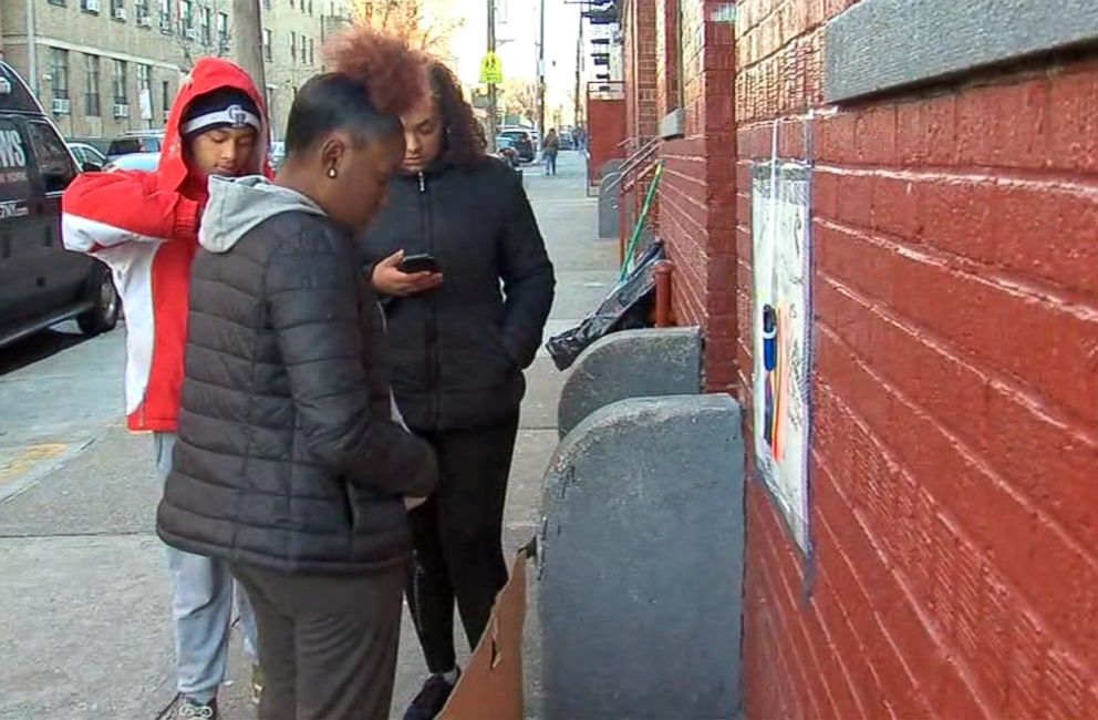 PHOTO: Friends of 17-year-old Angel Reyes-Godoy gather around the stoop where he would often hang out on Bainbridge Avenue in the Bronx borough of New York, Dec. 11, 2018.