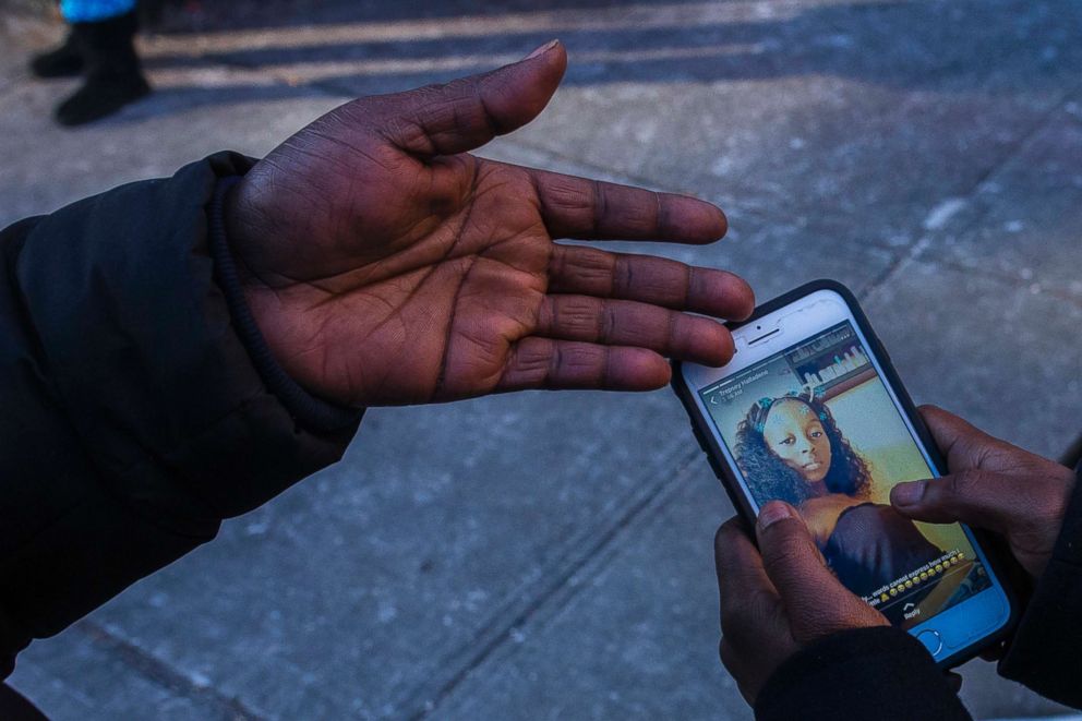 PHOTO: Sasha Answer, resident of an apartment building where a deadly fire took place, talks to a friend as he displays a picture published on social media of Shawntay Young, who died in the fire, in the Bronx borough of New York, Dec. 29, 2017.