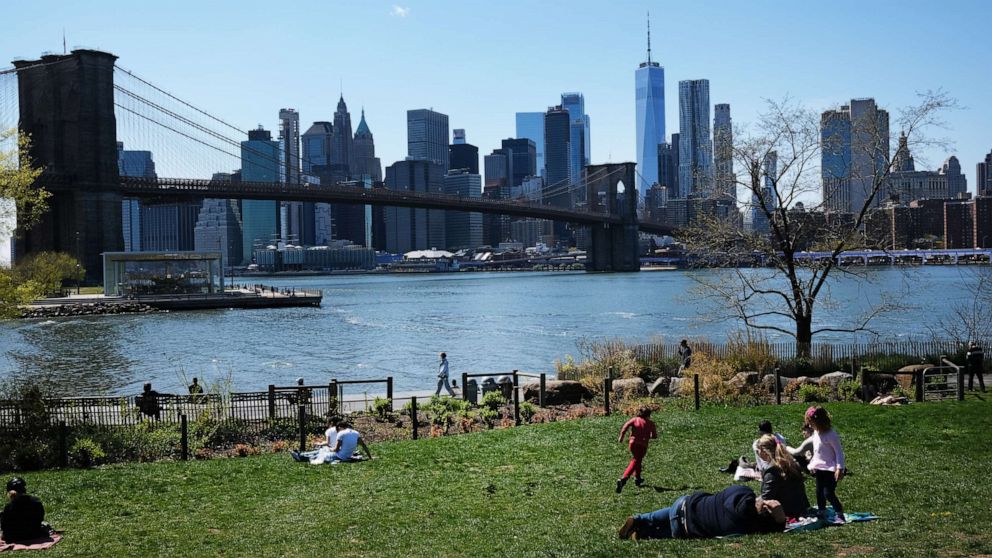 PHOTO: People keep their personal distance as they enjoy a spring afternoon in Brooklyn Bridge Park in the Brooklyn borough of New York City on April 28, 2020.