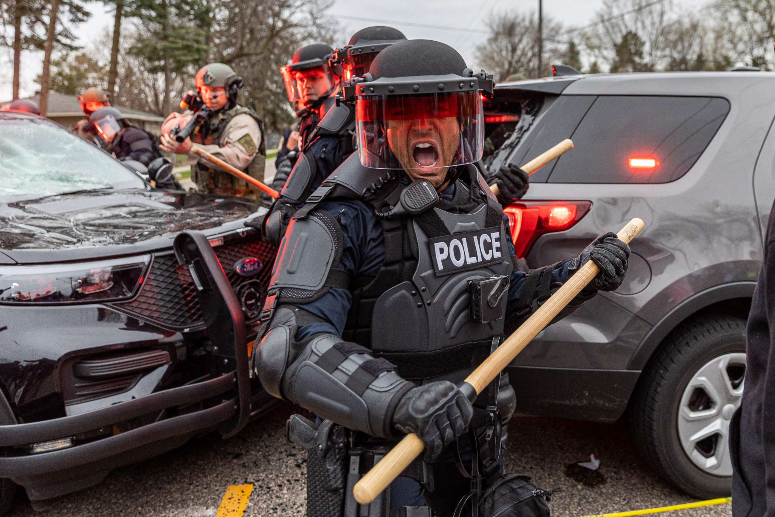 PHOTO: Police take cover as they clash with protesters after an officer shot and killed a driver during a traffic stop in Brooklyn Center, Minnesota, on April 11, 2021.