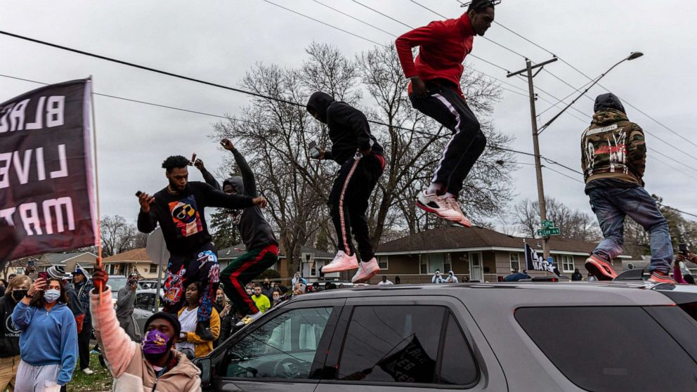 PHOTO: Protesters stand on top of a car as they clash with police after an officer shot and killed a driver during a traffic stop in Brooklyn Center, Minnesota, on April 11, 2021.