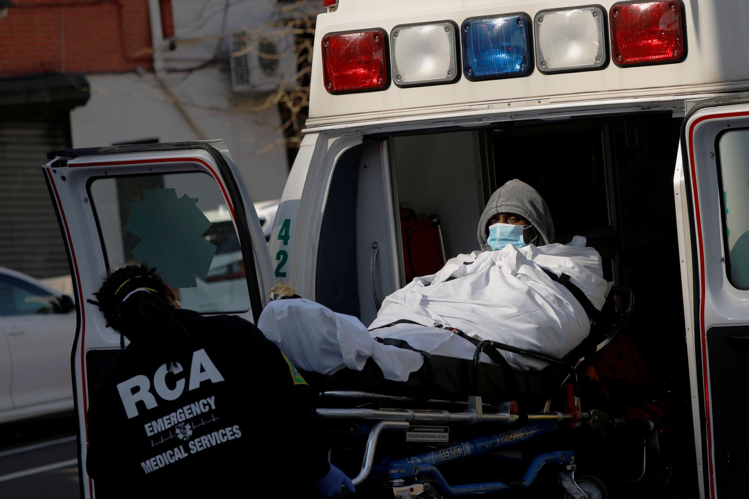 PHOTO: E.M.T.'s load a patient into an ambulance as health workers continued to test people for coronavirus disease (COVID-19) outside the Brooklyn Hospital Center in Brooklyn, New York, March 27, 2020.
