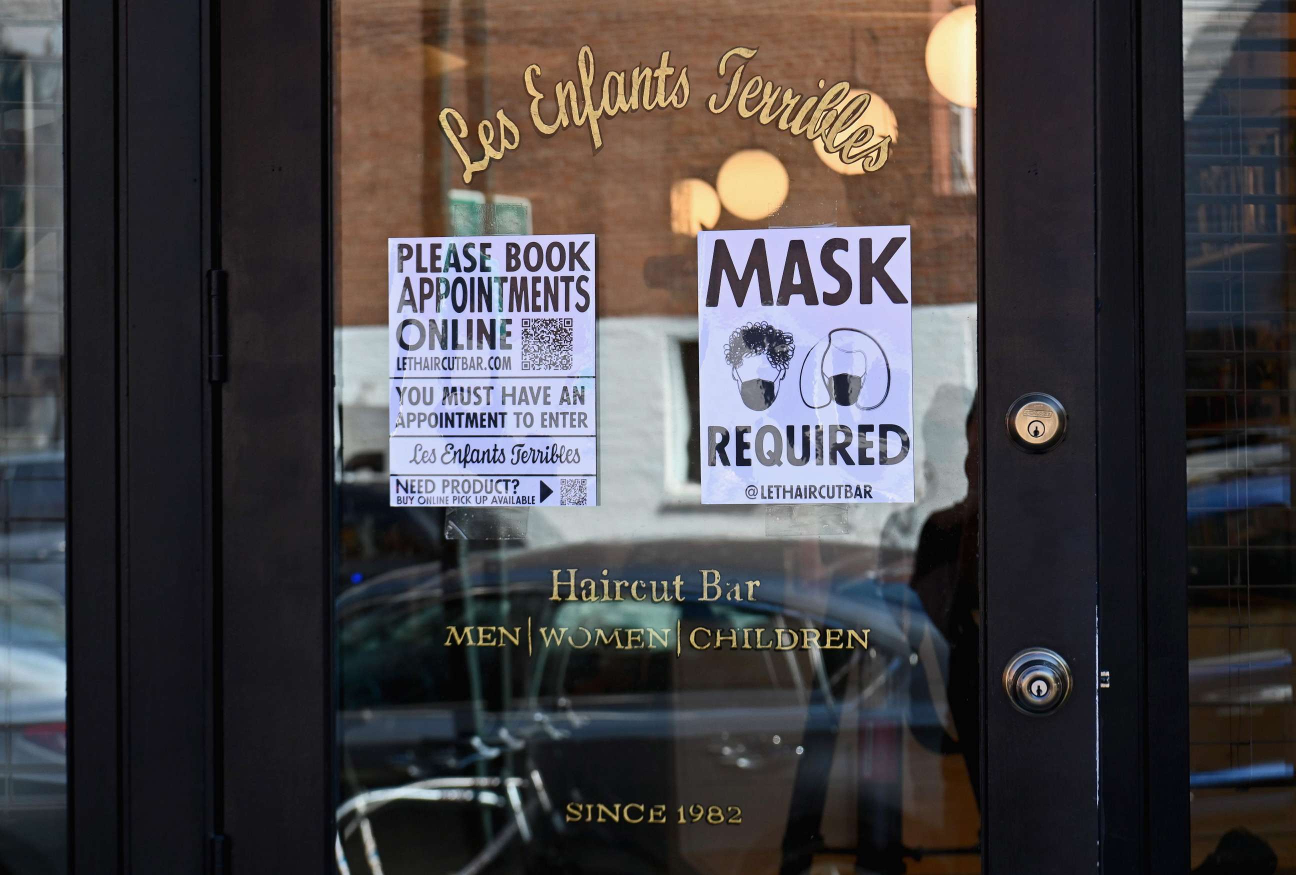 PHOTO: A "Mask Required" sign is seen outside 'Les Enfants Terribles' hair salon and barber shop amid the coronavirus pandemic, June 22, 2020 in Brooklyn, New York City.