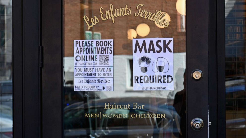 PHOTO: A "Mask Required" sign is seen outside 'Les Enfants Terribles' hair salon and barber shop amid the coronavirus pandemic, June 22, 2020 in Brooklyn, New York City.