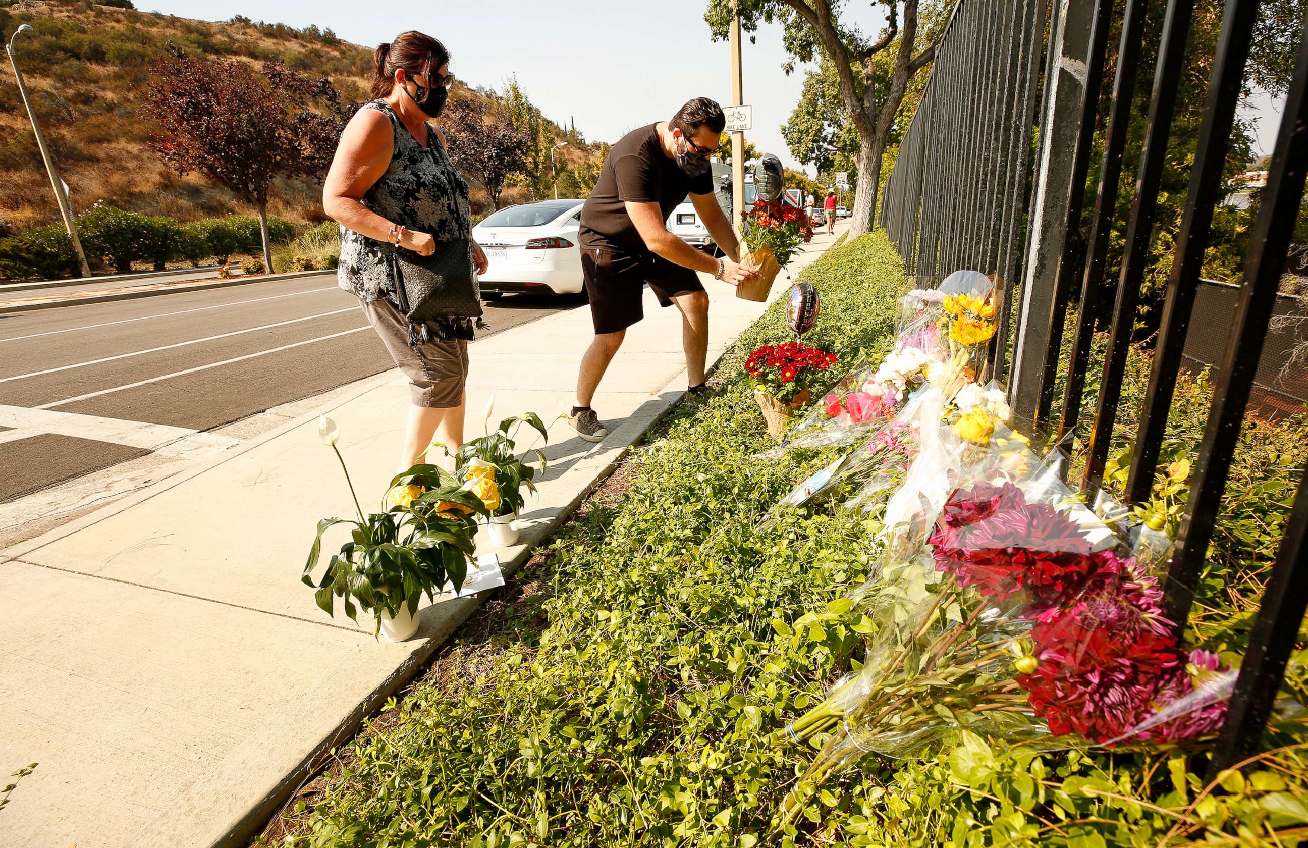 PHOTO: Lorraine Maralian and her son Anthony Maralian of Westlake Village place flowers and pray at a growing memorial for two brothers who were fatally injured while crossing  Triunfo Canyon Road, Westlake Village, Calif., Sept. 30, 2020.