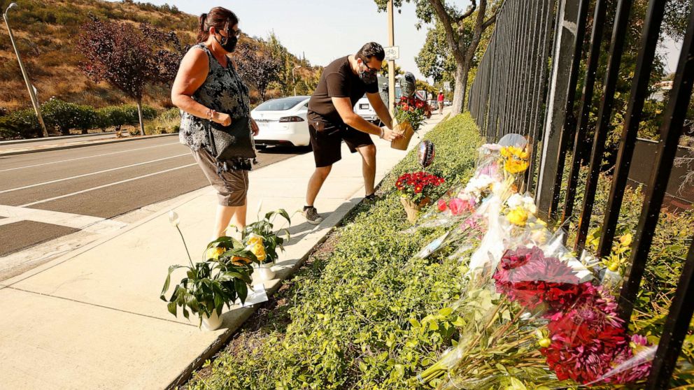 PHOTO: Lorraine Maralian and her son Anthony Maralian of Westlake Village place flowers and pray at a growing memorial for two brothers who were fatally injured while crossing  Triunfo Canyon Road, Westlake Village, Calif., Sept. 30, 2020.