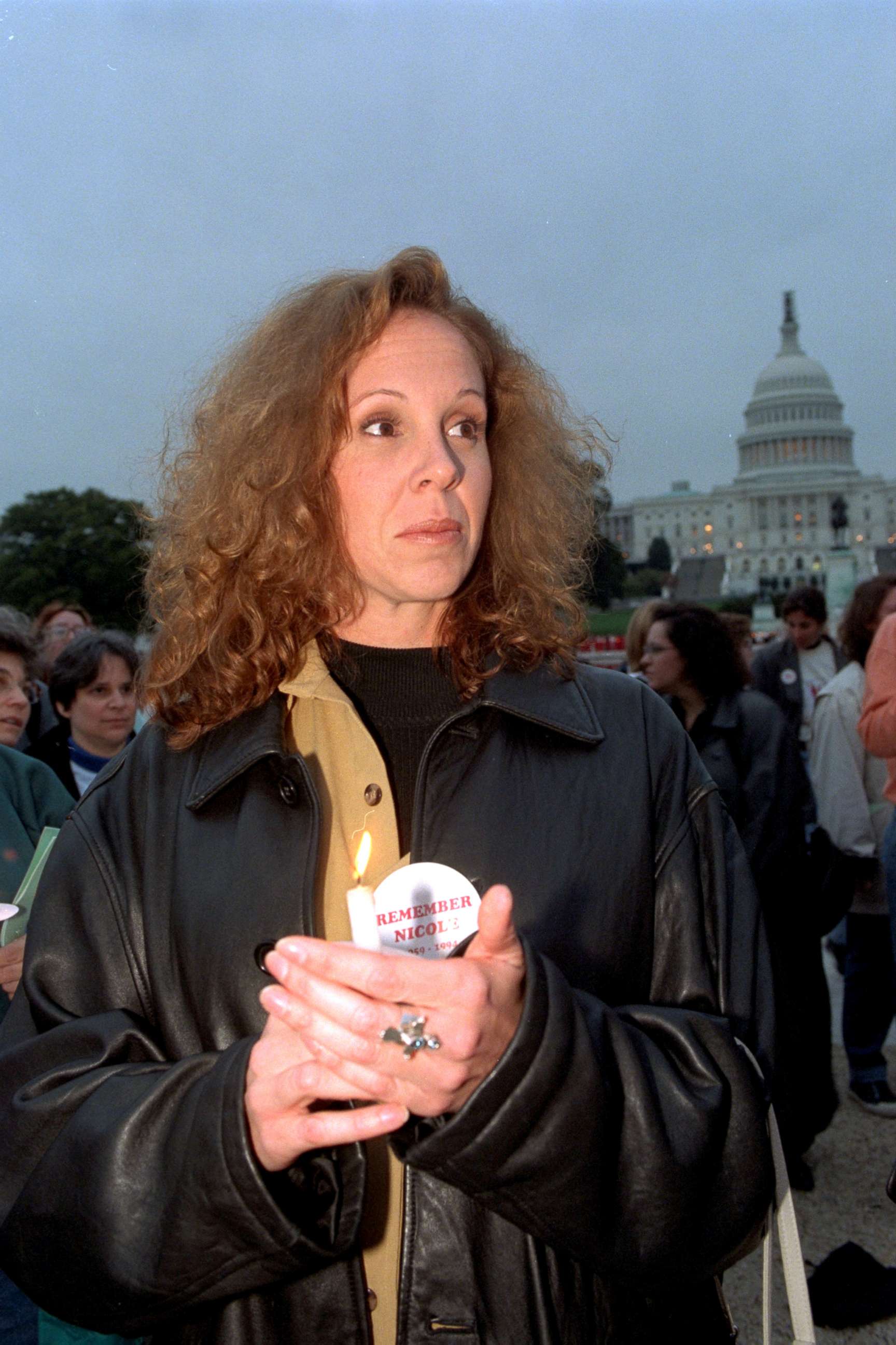 PHOTO: Tanya Brown, sister of Nicole Brown Simpson, holds a candle during a vigil for victims of domestic violence, Oct. 18, 1997, in front of the Capitol.