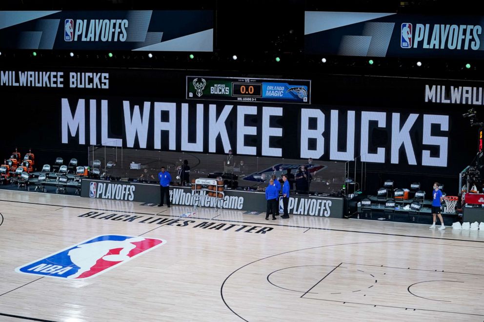 PHOTO: Officials stand beside an empty court after the scheduled start of game five between the Milwaukee Bucks and the Orlando Magic, Aug. 26, 2020, in Lake Buena Vista, Fla.