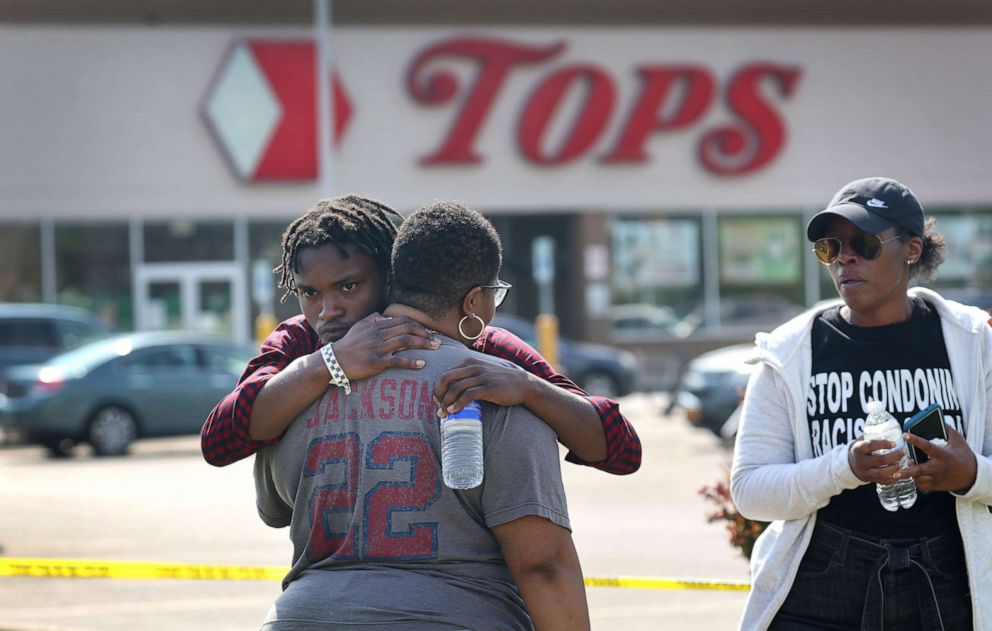 PHOTO: People gathering outside of Tops market embrace a day after a gunman killed ten people in a mass shooting, May 15, 2022, in Buffalo, N.Y. 