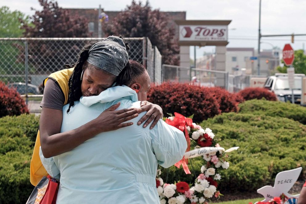 PHOTO: People embrace near a memorial for the shooting victims outside of Tops grocery store on May 20, 2022 in Buffalo, N.Y. 18-year-old Payton Gendron is accused of the mass shooting that killed 10 people at the Tops grocery store on May 14th.