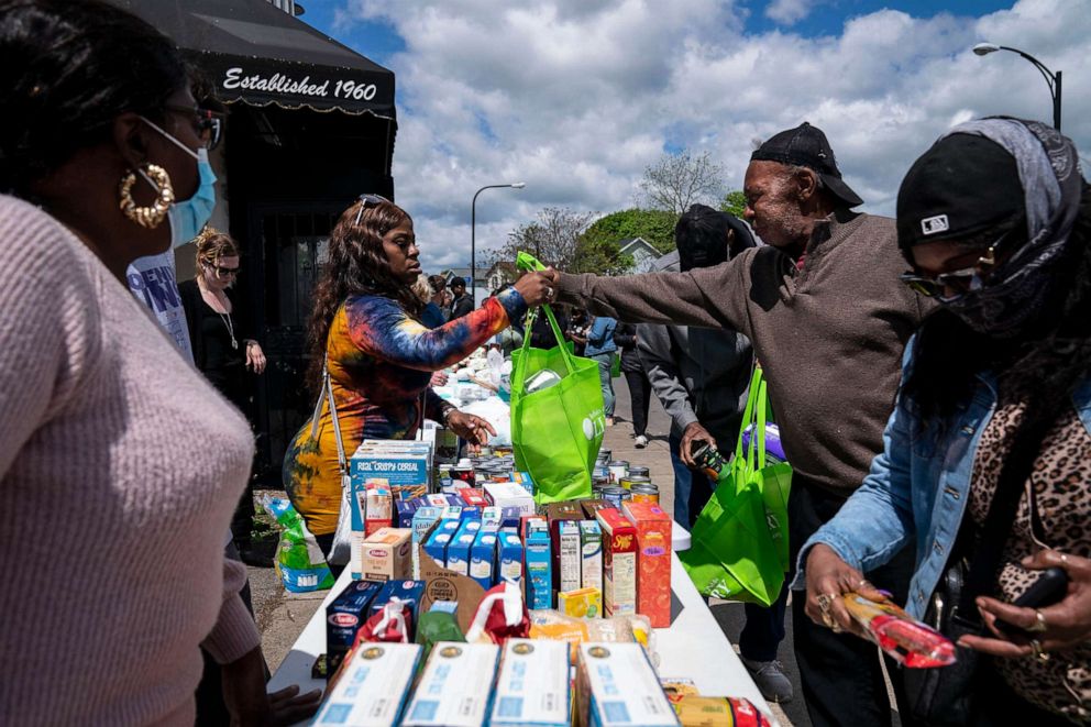 PHOTO: People pick up food and supplies from a food distribution event put on by Buffalo Community Fridge along Ferry street, just blocks away from Tops Friendly Market, on May 17, 2022, in Buffalo, N.Y.
