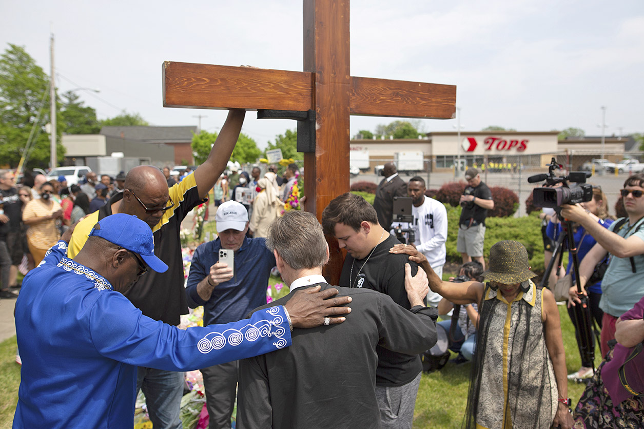 PHOTO: A group prays at the site of a memorial for the victims of the Buffalo supermarket shooting outside the Tops Friendly Market, on May 21, 2022, in Buffalo, N.Y.