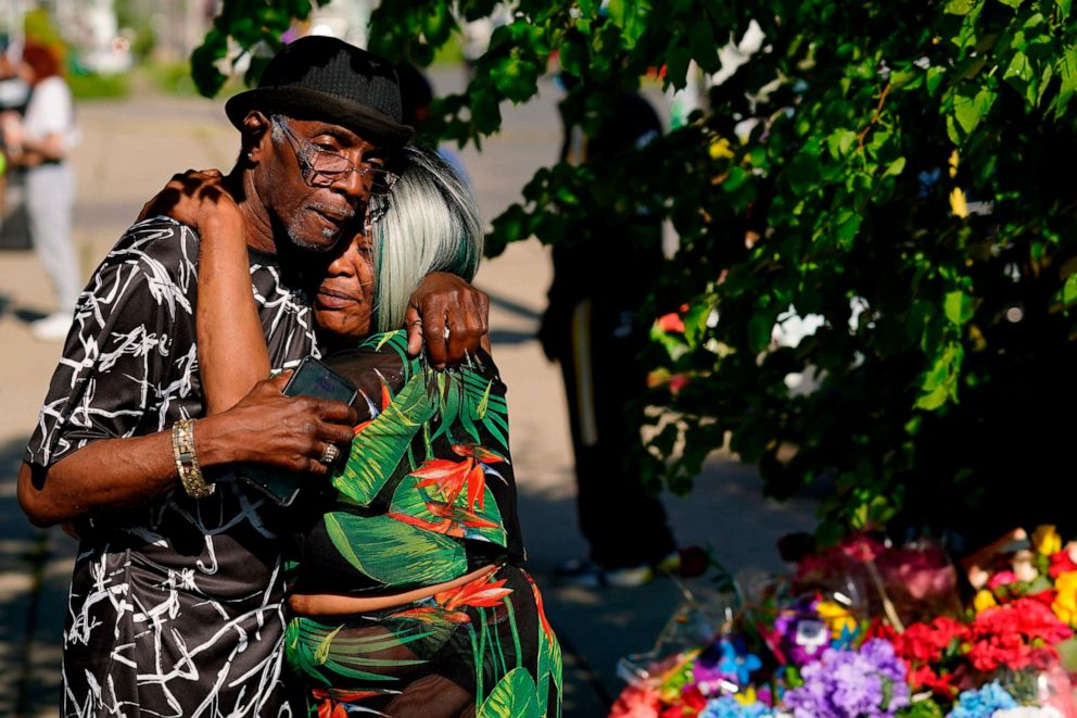 PHOTO: People embrace outside the scene of a mass shooting at a Tops supermarket a day earlier, in Buffalo, N.Y., May 15, 2022.