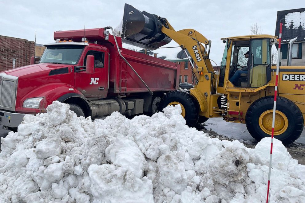 PHOTO: A front loader dumps snow into a dump truck along a residential street in Buffalo, N.Y. , on Dec. 29, 2022.