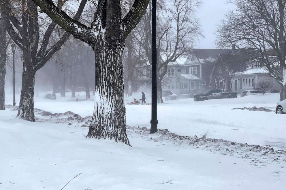 PHOTO: A person clears snow from the sidewalk during a snowstorm, Dec. 24, 2022 in Buffalo, N.Y.