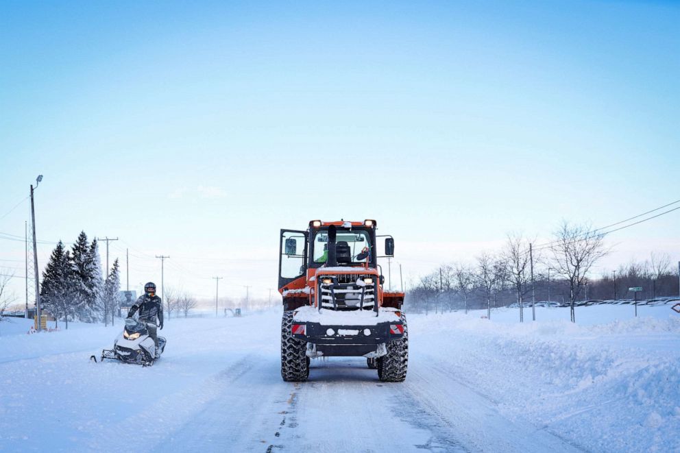 PHOTO: A man on a snowmobile speaks to a plow in the road following a winter storm that hit the Buffalo region in Amherst, New York, December 25, 2022.