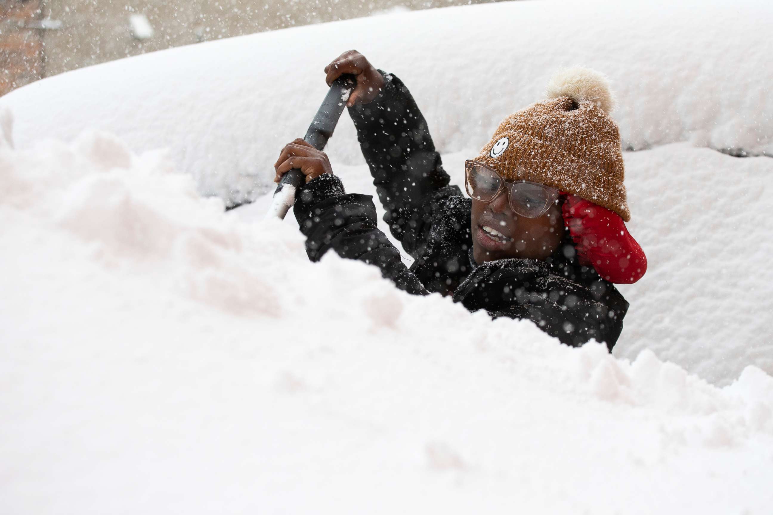 PHOTO: Zaria Black, 24, from Buffalo, clears off her car as snow falls Friday, Nov. 18, 2022, in Buffalo, N.Y.