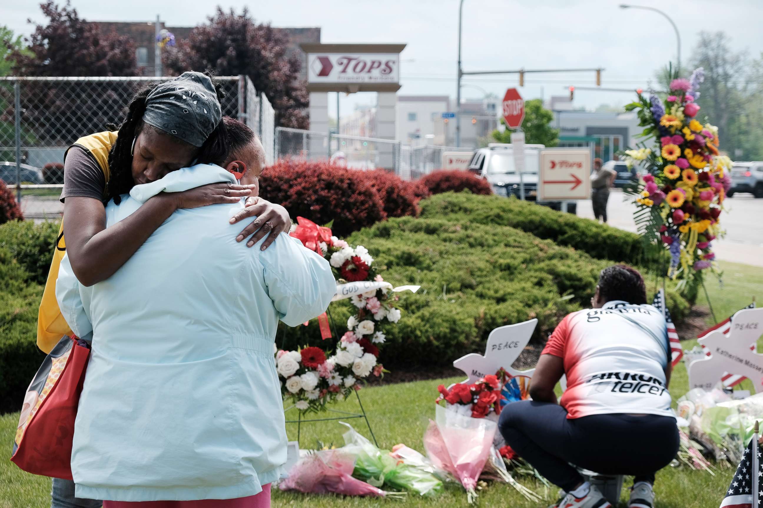 PHOTO: People embrace near a memorial for the shooting victims outside of Tops grocery store, May 20, 2022, in Buffalo, N.Y., where 10 people died during a mass shooting on May 14.