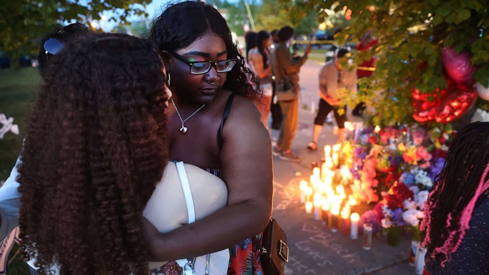 PHOTO: Mourners support each other while visiting a makeshift memorial outside of Tops market, May 15, 2022 in Buffalo, New York.
