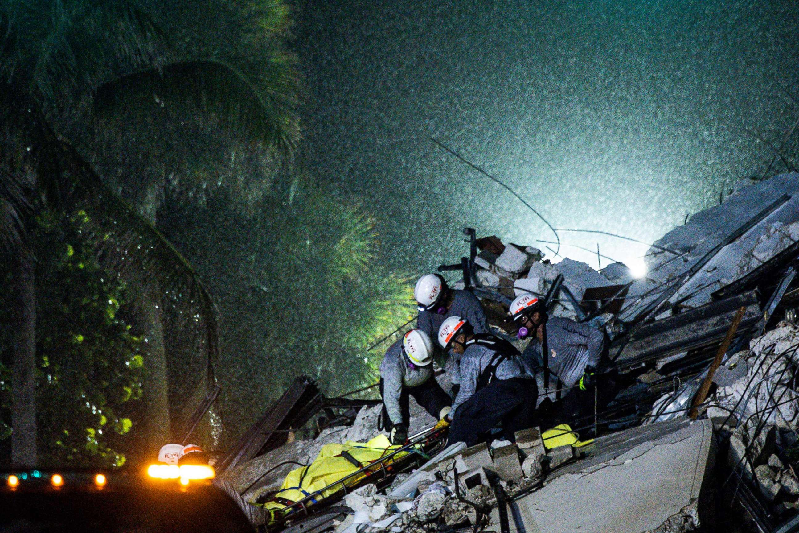 PHOTO: Search and Rescue personnel pull a body out of the rubble after the partial collapse of the Champlain Towers South in Surfside, north of Miami Beach, on June 24, 2021.