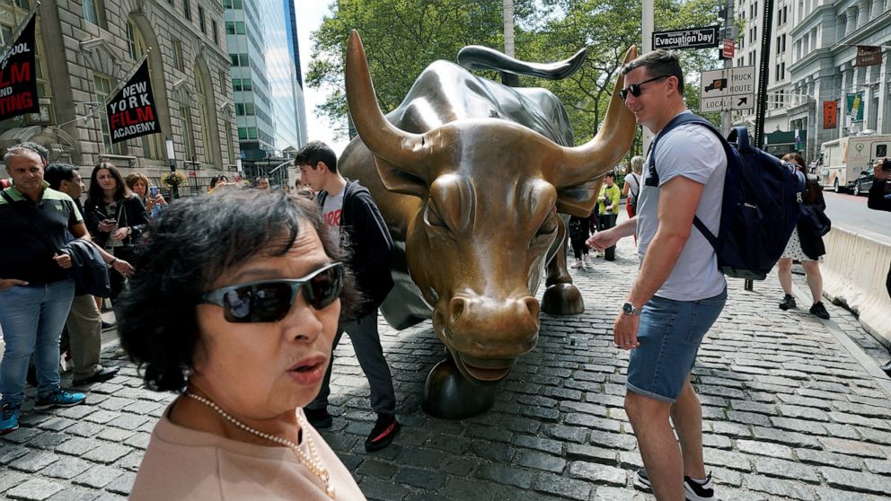 PHOTO: Pedestrians view the damage, visible near the base of one of its horns, to the iconic bronze Charging Bull statue on Wall Street in New York, Sept. 8, 2019.