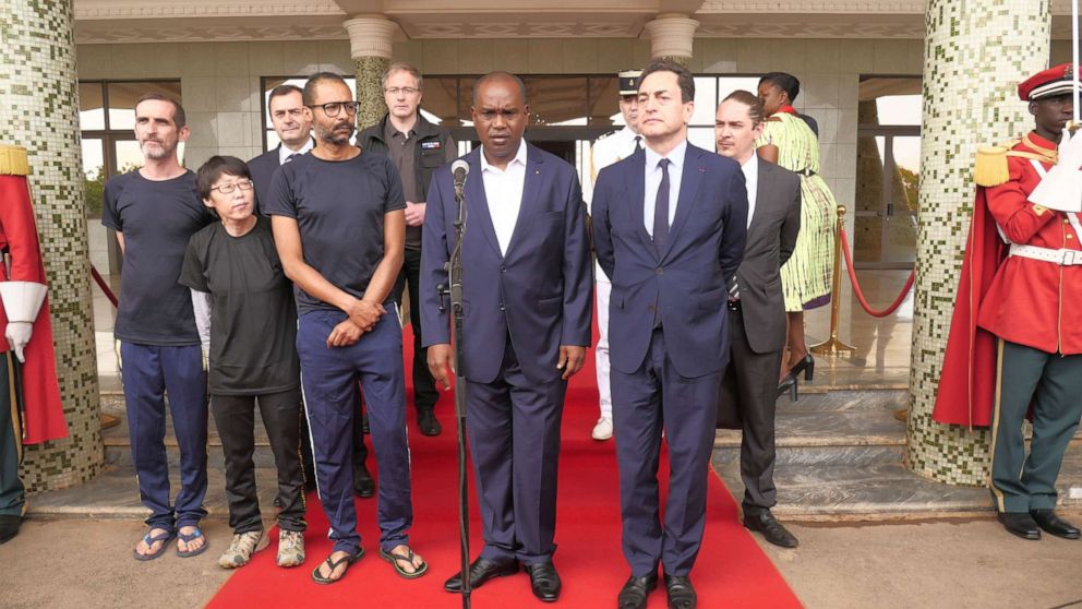 PHOTO:Burkina Faso's Foreign Minister Alpha Barry addresses media next to freed hostages during a presser following a meeting with Burkina Faso's President at Kosyam Presidential Palace in Ouagadougou, May 11, 2019. 