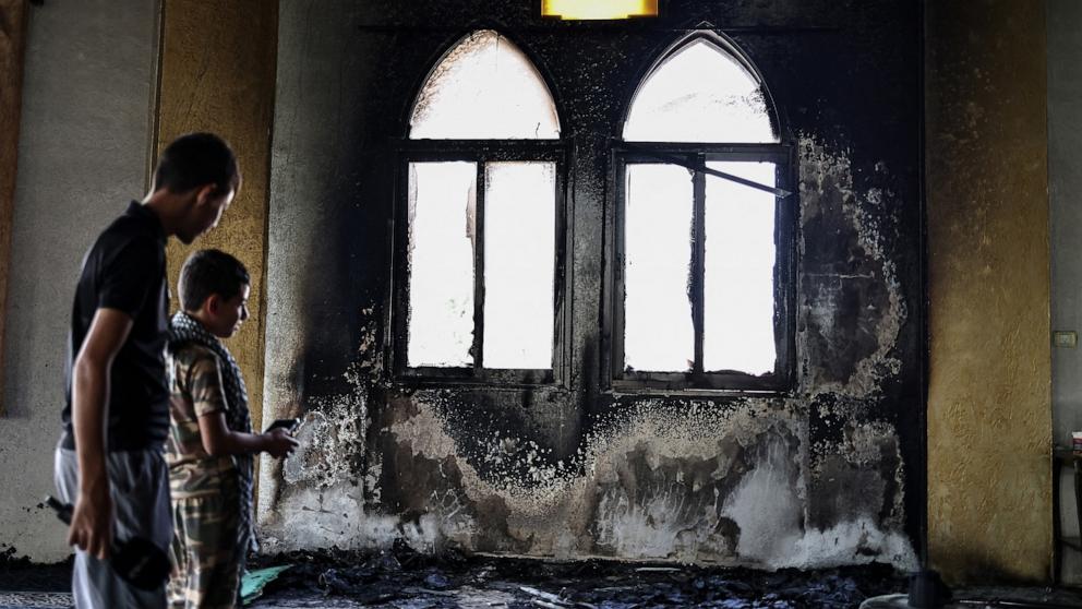PHOTO: Young Palestinians look at the damage in the Hajja Hamida Mosque after it was reportedly set on fire and vandalized by Israeli settlers in the Palestinian village of Deir Istiya, near Salfit in the Israeli-occupied West Bank, on November 13, 2025.