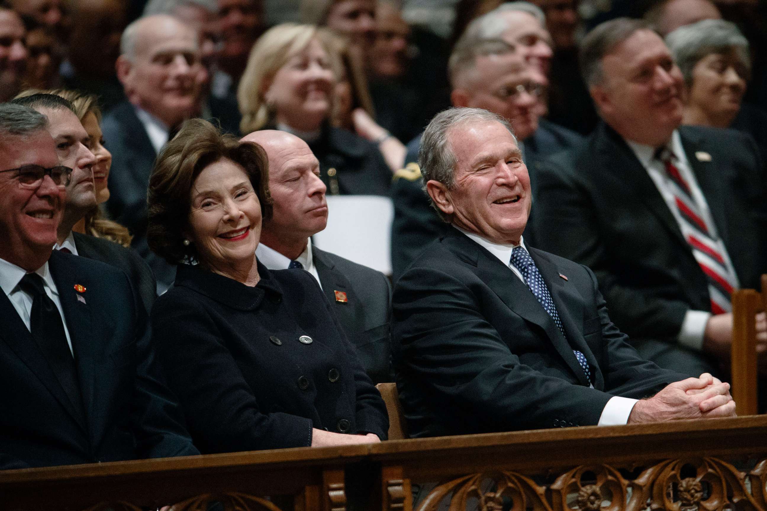 PHOTO: Jeb Bush, Laura Bush, and former President George W. Bush share a laugh as a story is told about former President George H.W. Bush during a State funeral at the National Cathedral, Dec. 5, 2018, in Washington.