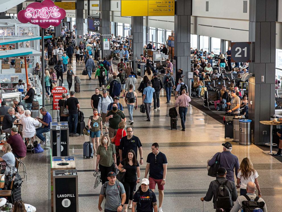 PHOTO: Travelers walk through the junction of the east and west airport terminals on May 23, 2022, in Austin, Texas.  