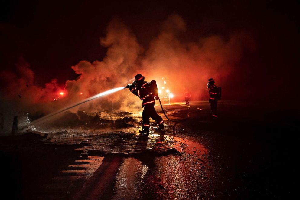 PHOTO: A firefighter sprays the smoldering remains of a vehicle on Interstate 5 as the Delta Fire burns in the Shasta-Trinity National Forest, Calif., on Wednesday, Sept. 5, 2018. 
