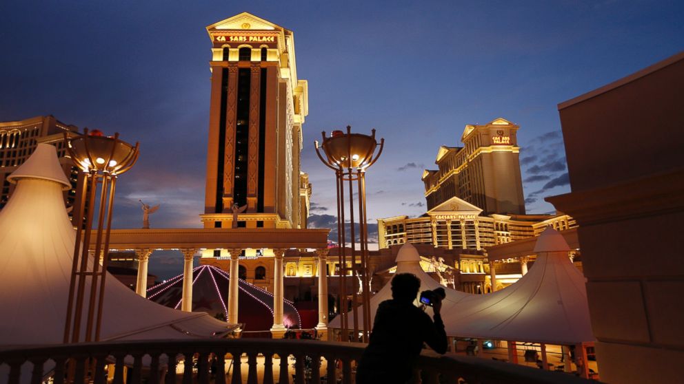 In this Jan. 12, 2015 file photo, a man takes pictures of Caesars Palace hotel and casino, in Las Vegas.